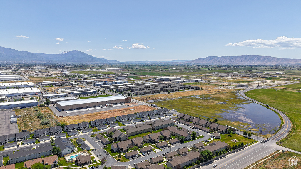 Aerial view of property and surrounding area with a mountainous background and nearby suburban area