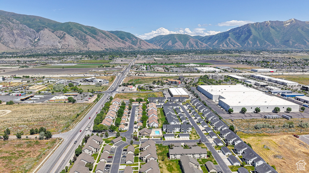 Aerial view of property and surrounding area with a mountain backdrop and nearby suburban area