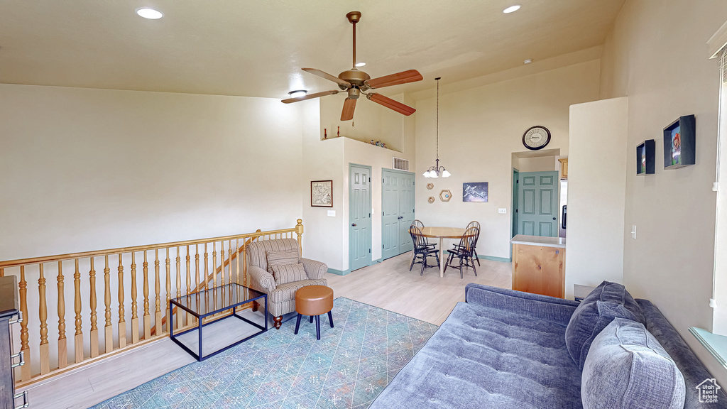 Sitting room with ceiling fan, wood finished floors, high vaulted ceiling, recessed lighting, and baseboards