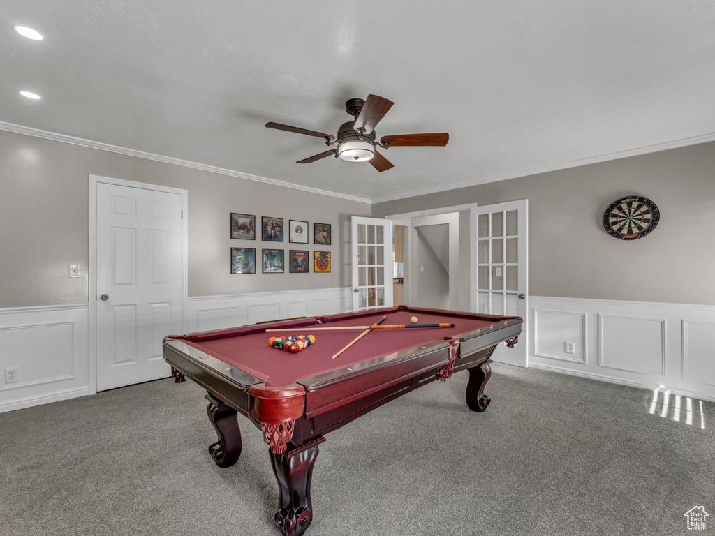Rec room featuring a wainscoted wall, french doors, carpet, ceiling fan, and ornamental molding