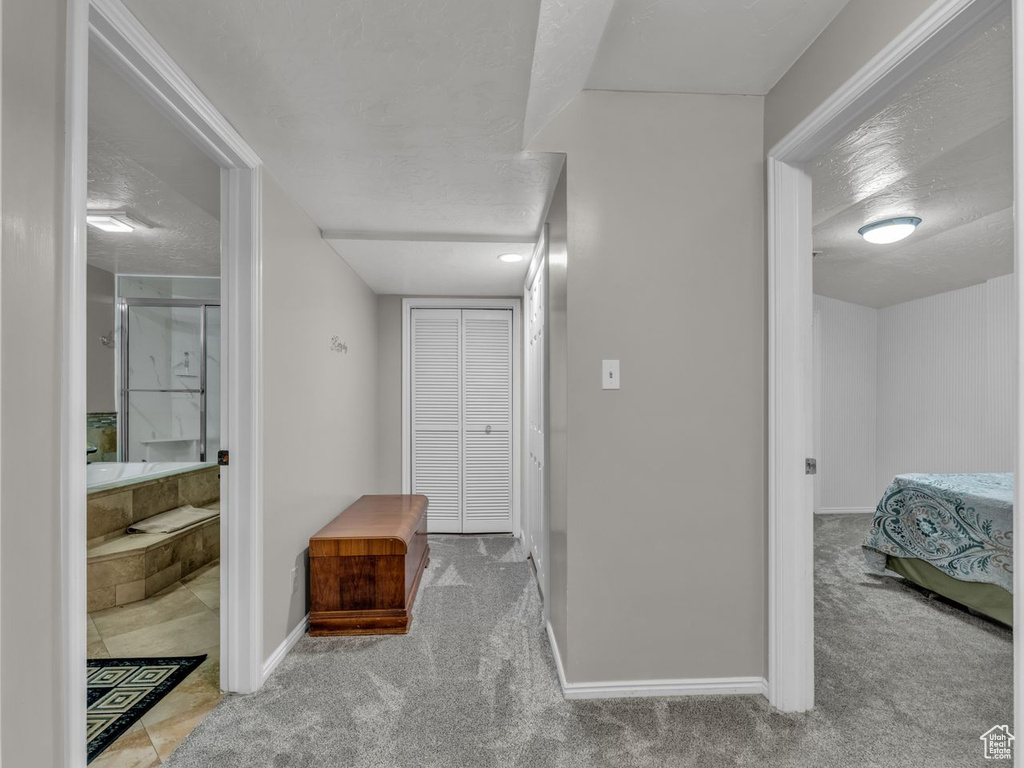 Corridor featuring carpet flooring and baseboards