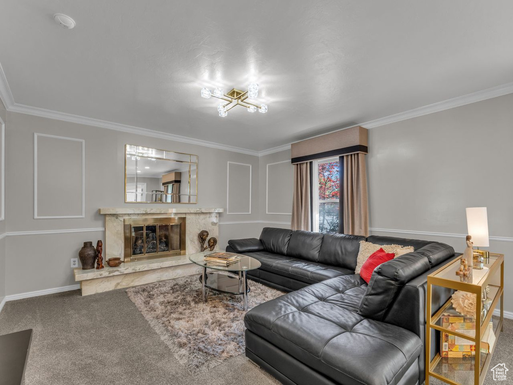 Living room featuring ornamental molding, baseboards, a high end fireplace, and carpet floors