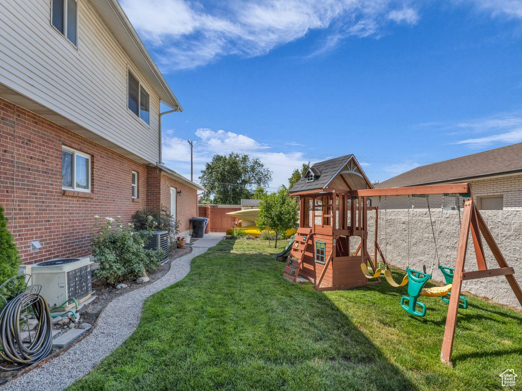 View of yard with a playground and central AC