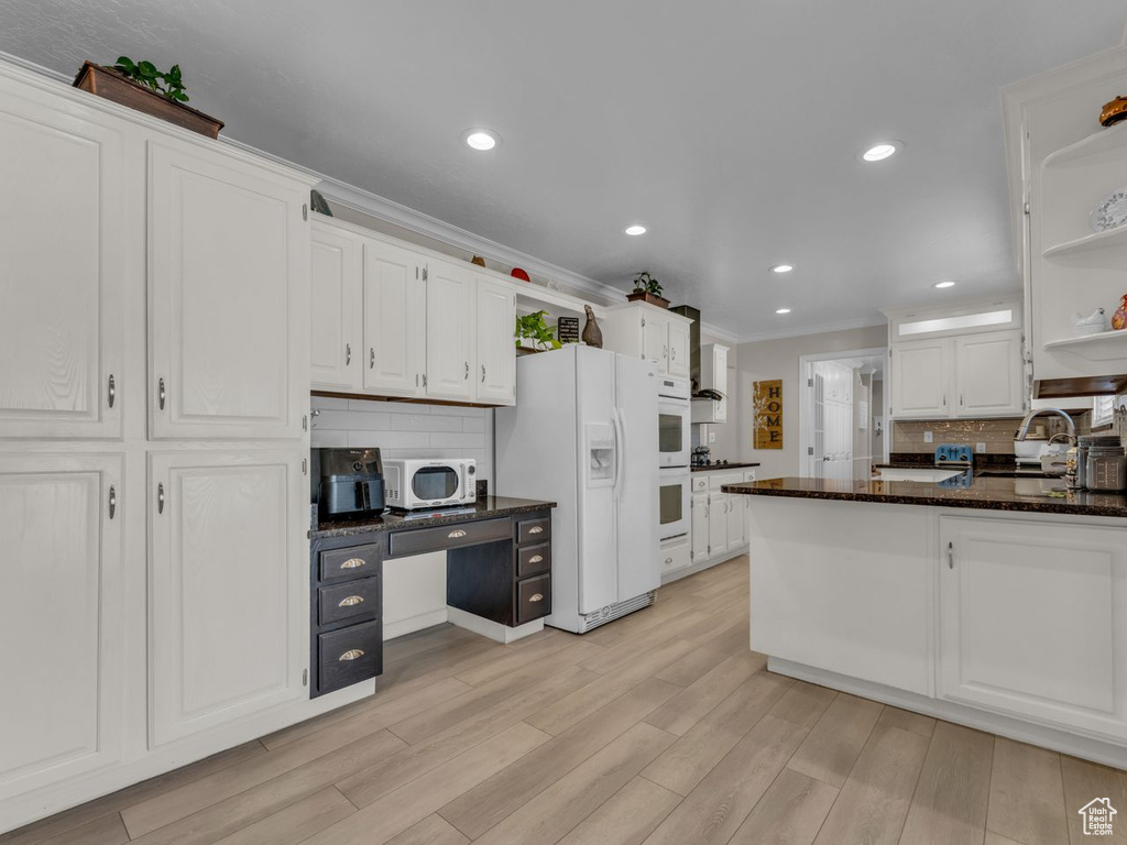 Kitchen featuring white appliances, open shelves, white cabinetry, decorative backsplash, and crown molding