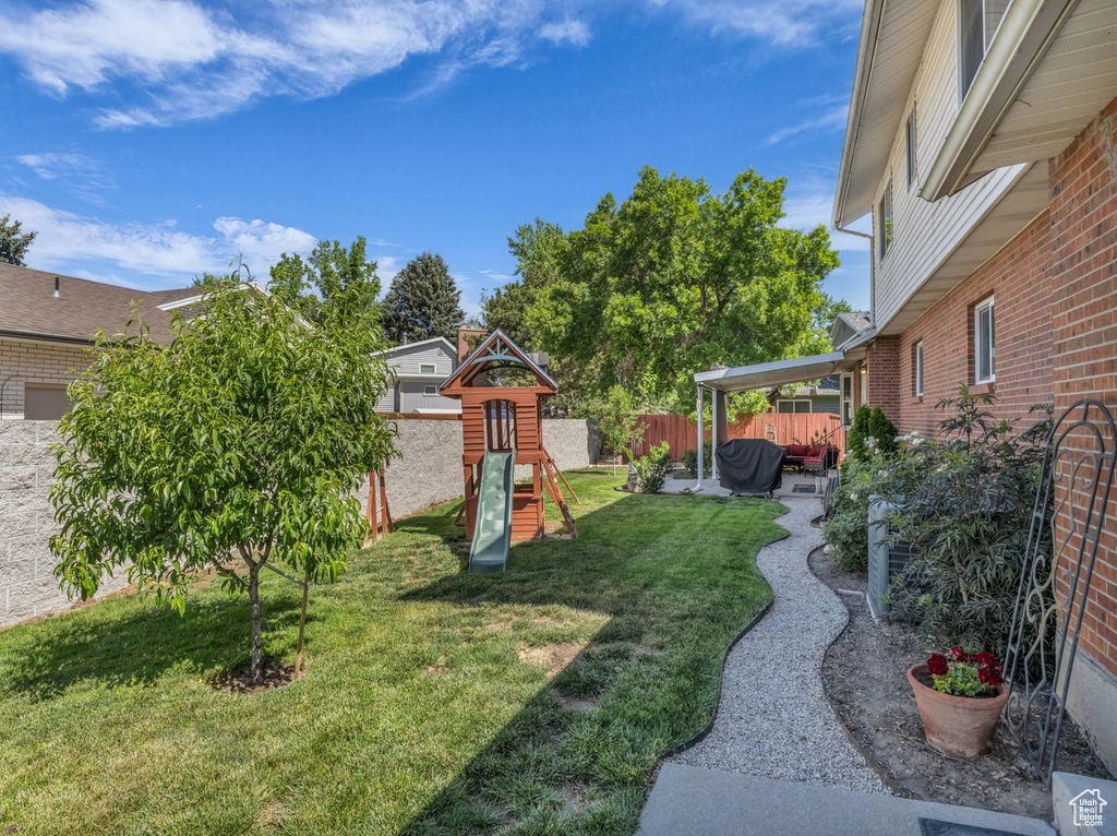 View of yard with a playground and a patio
