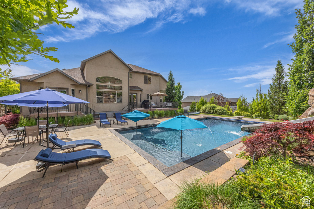 Outdoor pool with a patio and a wooden deck