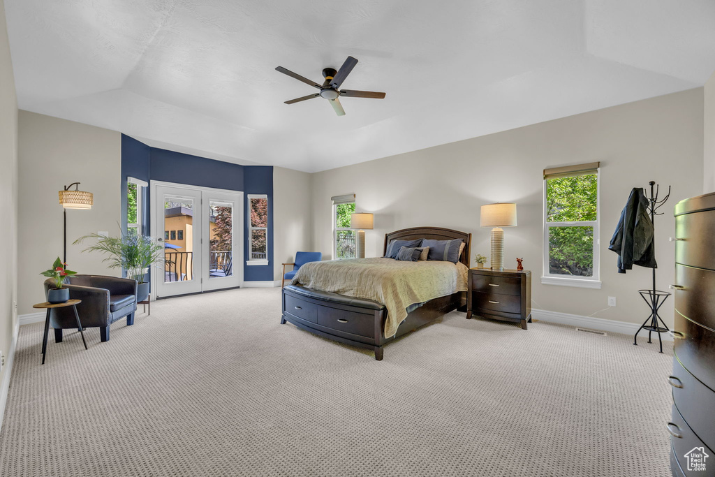 Carpeted bedroom featuring baseboards, multiple windows, access to outside, and a ceiling fan