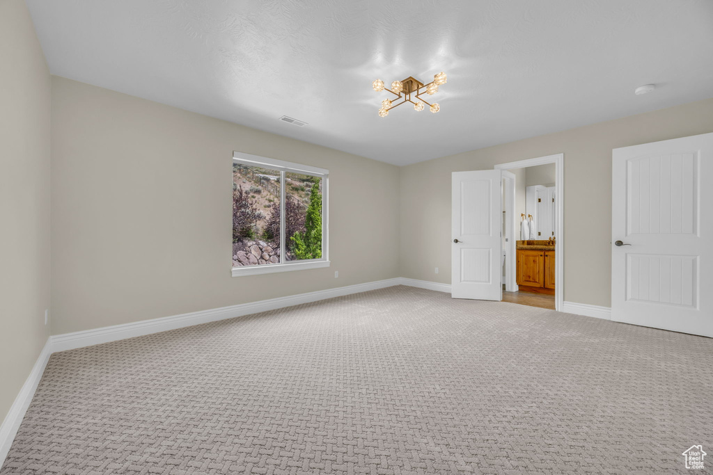 Unfurnished bedroom featuring light carpet and baseboards