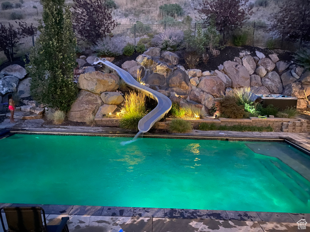 View of swimming pool with a water slide