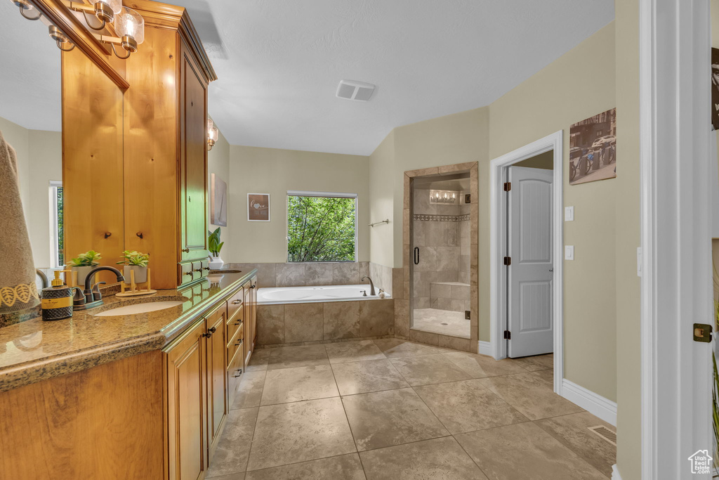 Full bath with vanity, a bath, a stall shower, and tile patterned floors