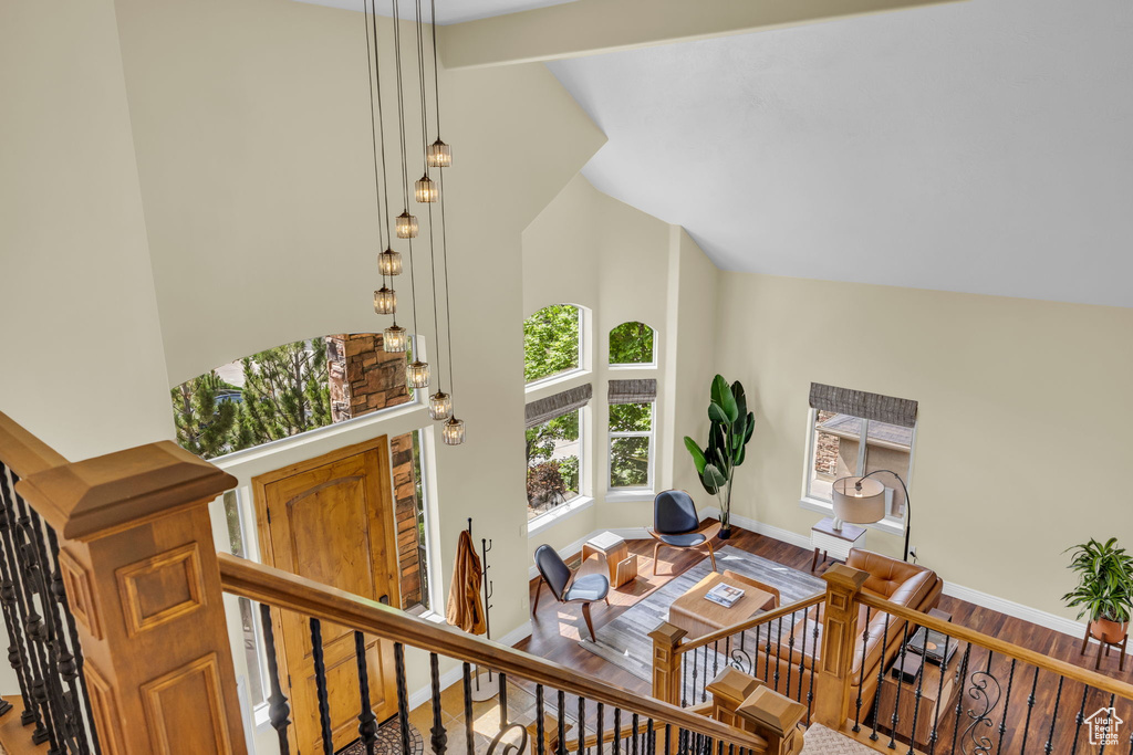 Living room with high vaulted ceiling, baseboards, and wood finished floors