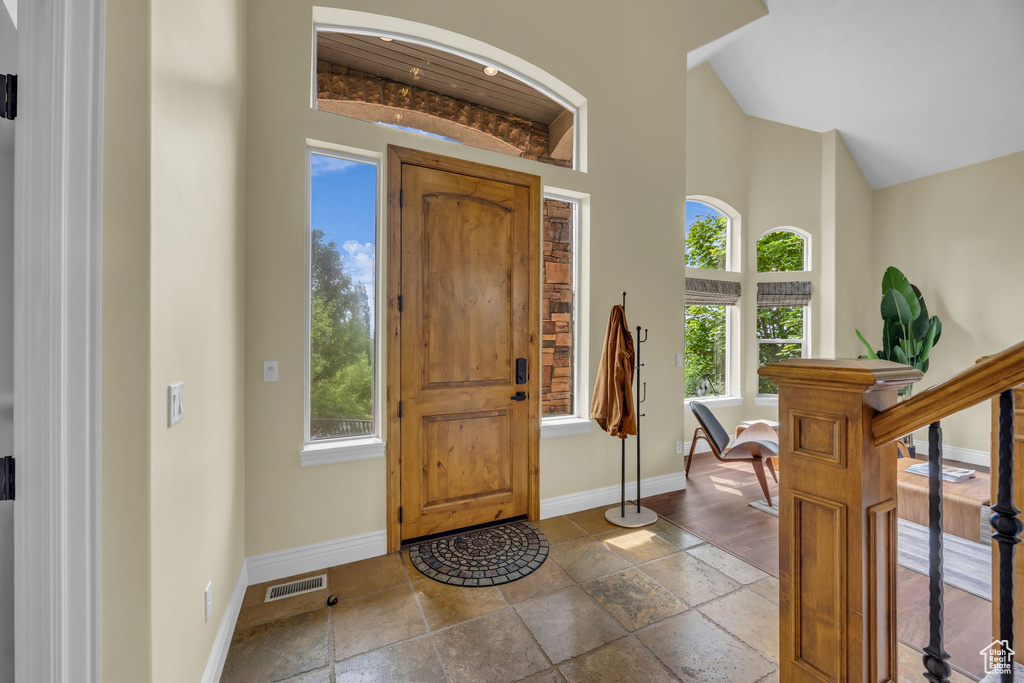 Foyer entrance with baseboards, healthy amount of natural light, and a high ceiling