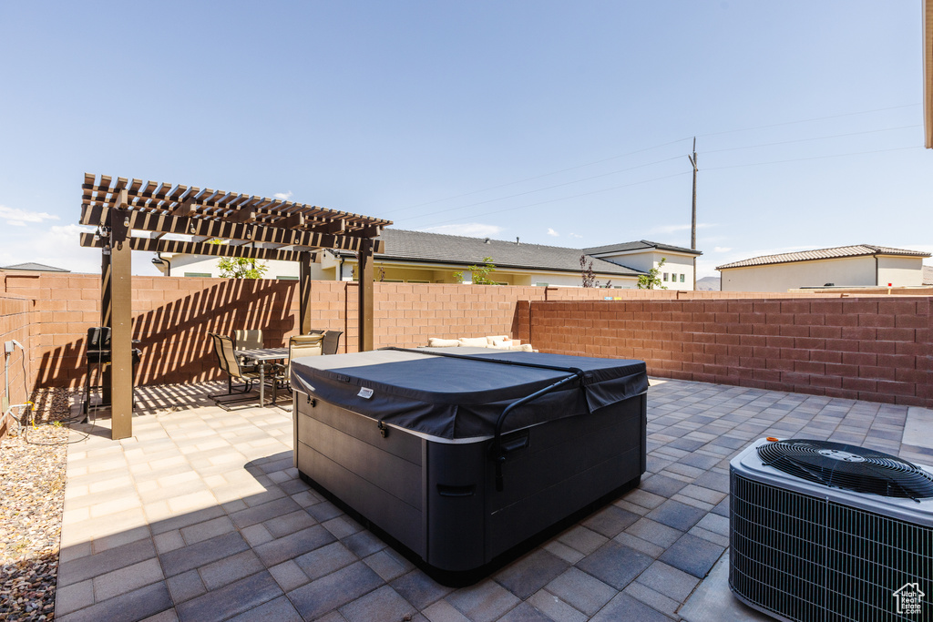 Fenced backyard featuring a hot tub, central AC unit, a patio, a pergola, and outdoor dining space