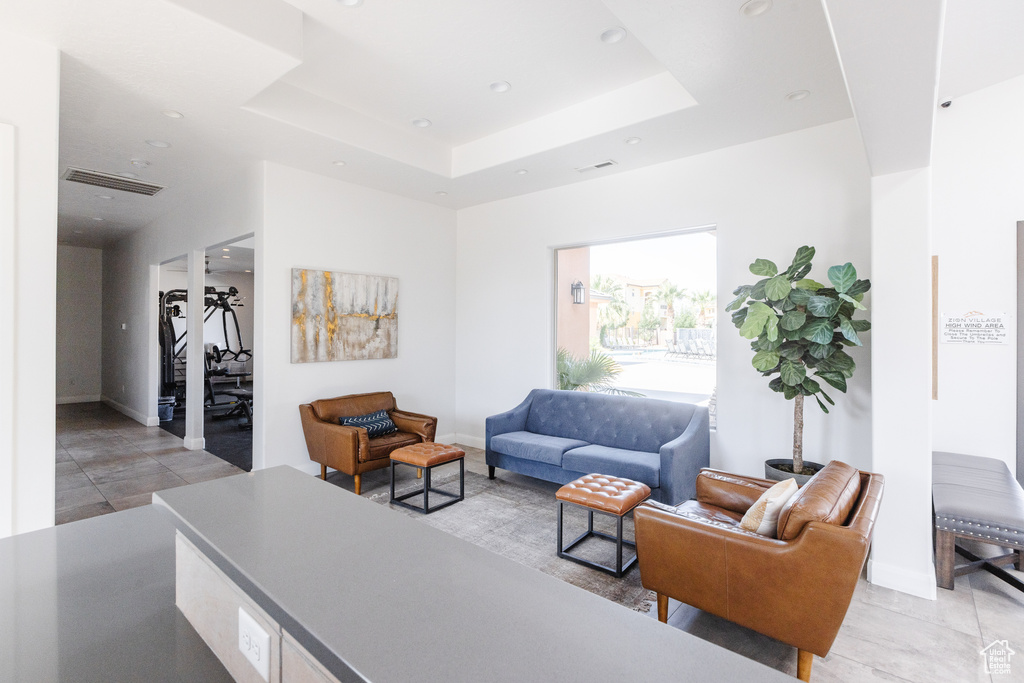 Living area featuring recessed lighting, baseboards, and a raised ceiling