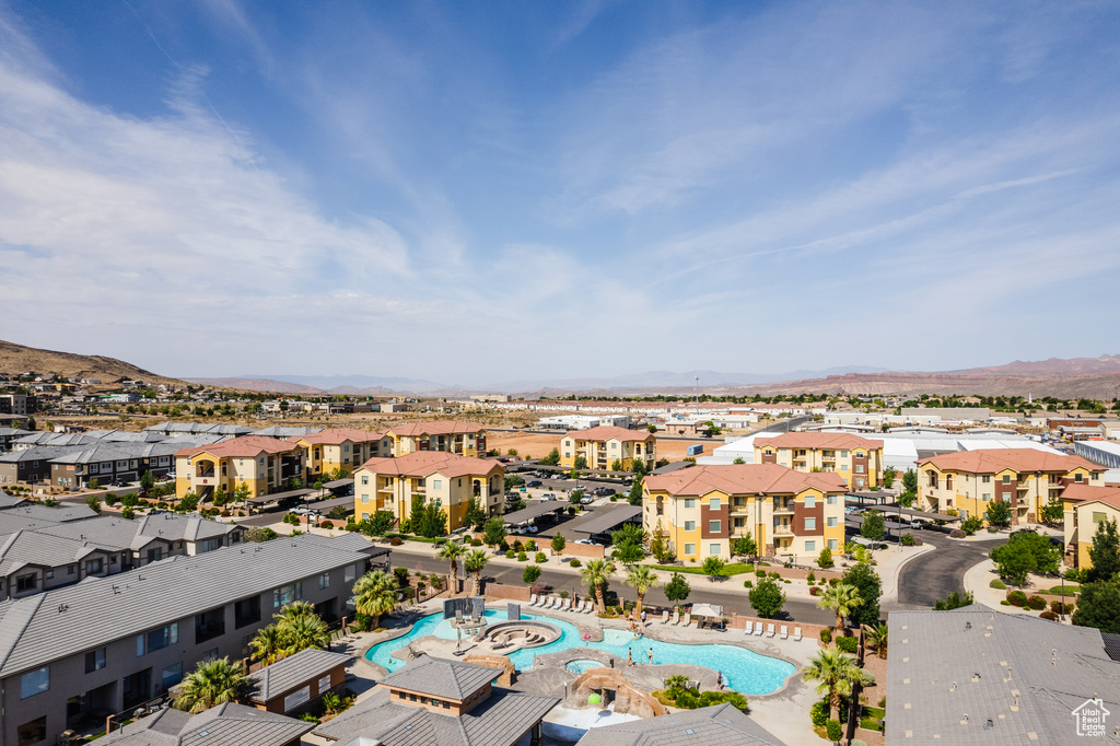 Aerial view of residential area featuring a pool and a mountainous background