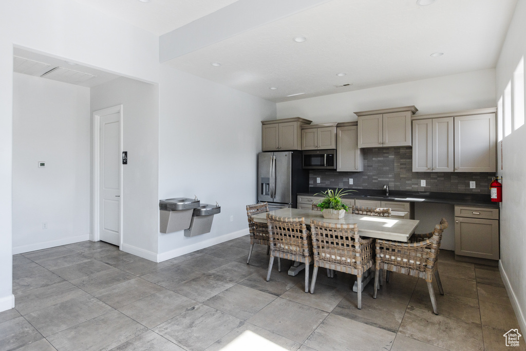 Kitchen featuring appliances with stainless steel finishes, dark countertops, backsplash, baseboards, and recessed lighting