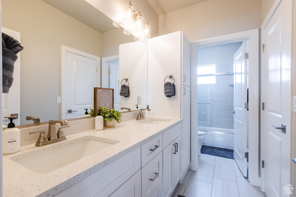 Full bath featuring double vanity, toilet, bathing tub / shower combination, and tile patterned floors