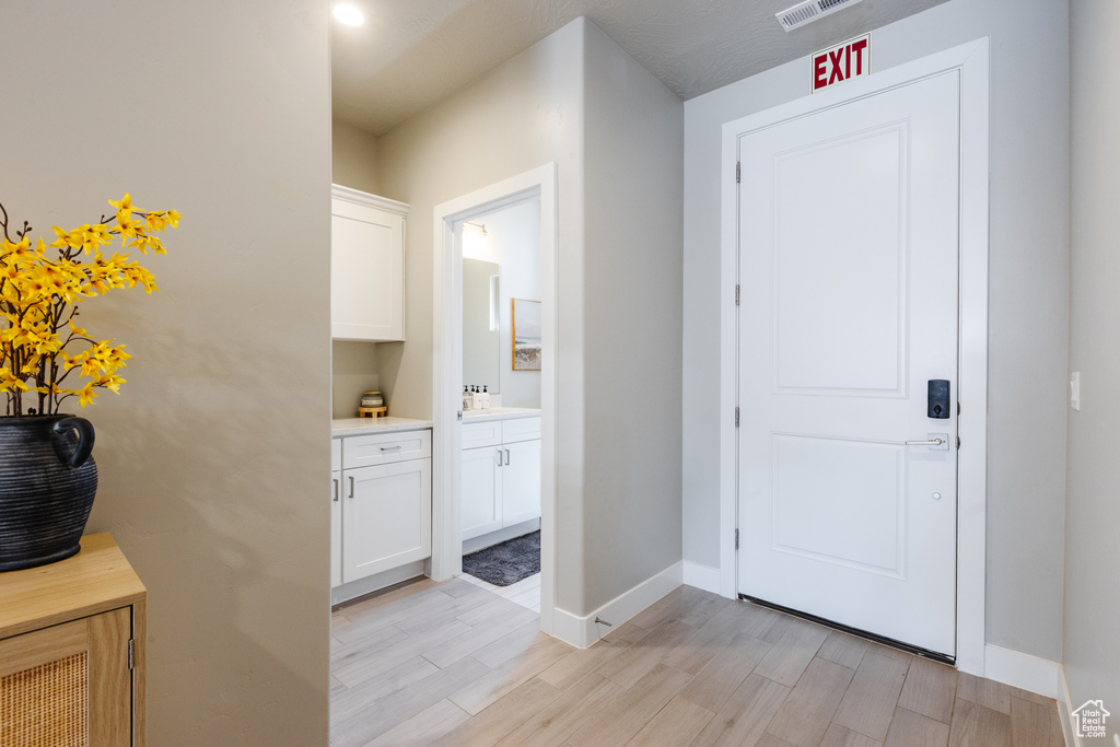 Hall with light wood-style flooring and baseboards