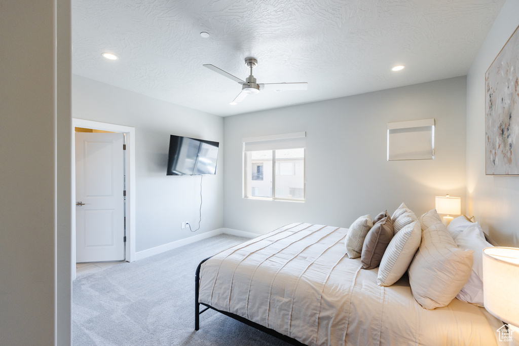 Carpeted bedroom with recessed lighting, baseboards, a ceiling fan, and a textured ceiling