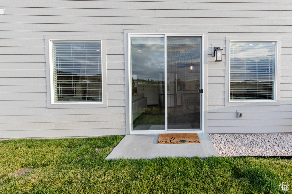 View of exterior entry with a lawn