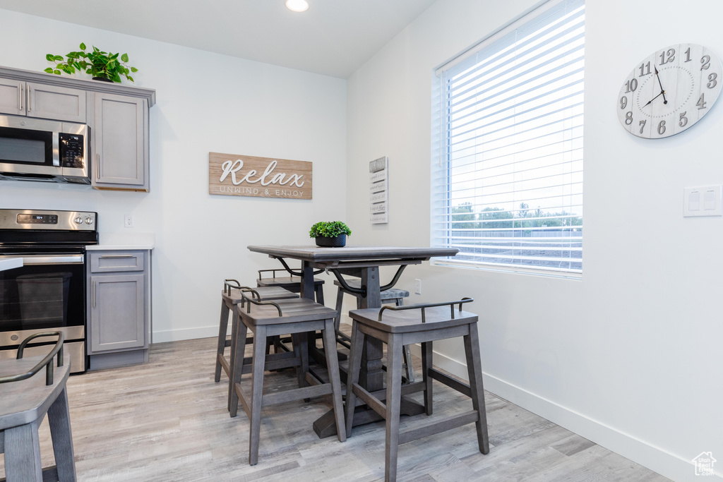 Dining room with light wood-style floors, baseboards, and recessed lighting