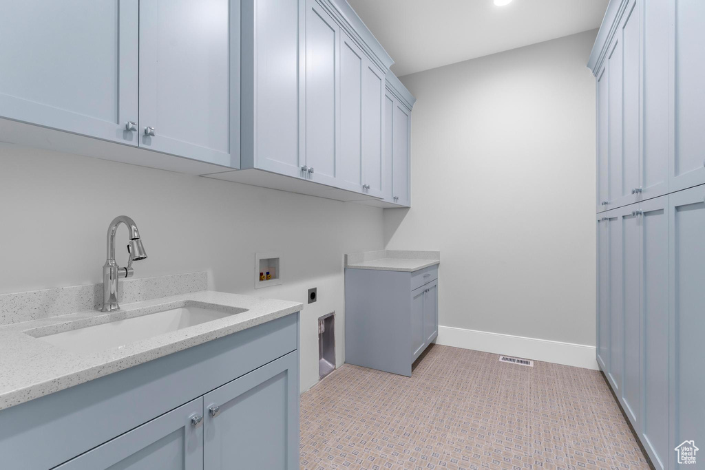 Washroom with electric dryer hookup, cabinet space, washer hookup, baseboards, and recessed lighting