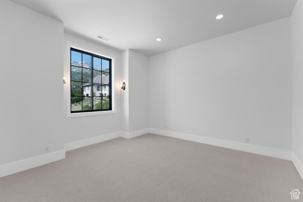 Unfurnished room featuring light colored carpet, recessed lighting, and baseboards