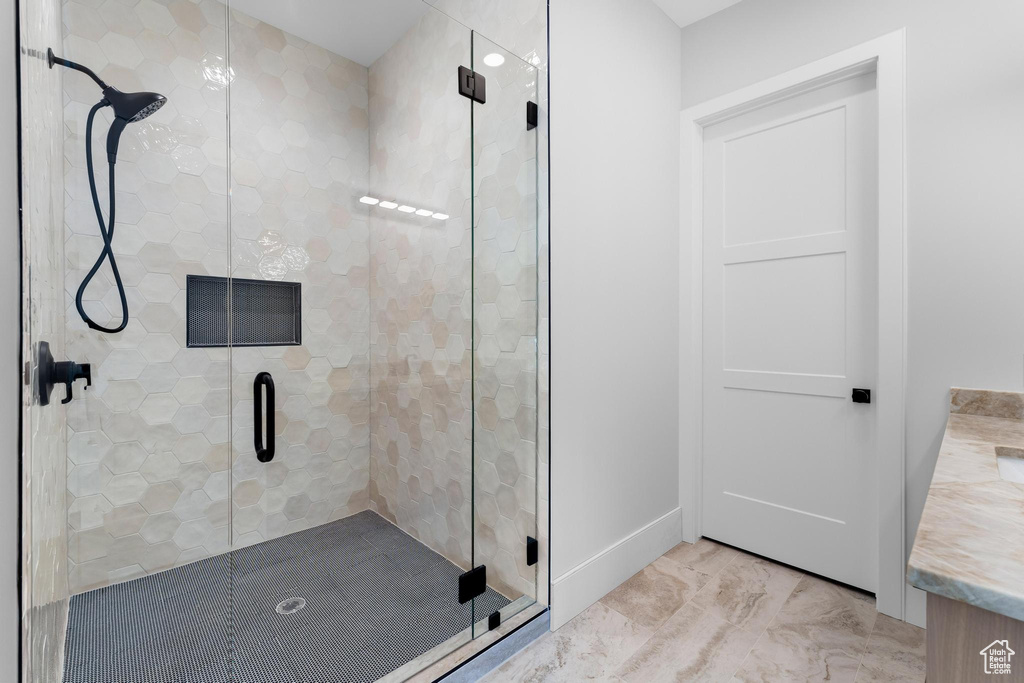 Full bath featuring a stall shower, marble finish floors, and vanity