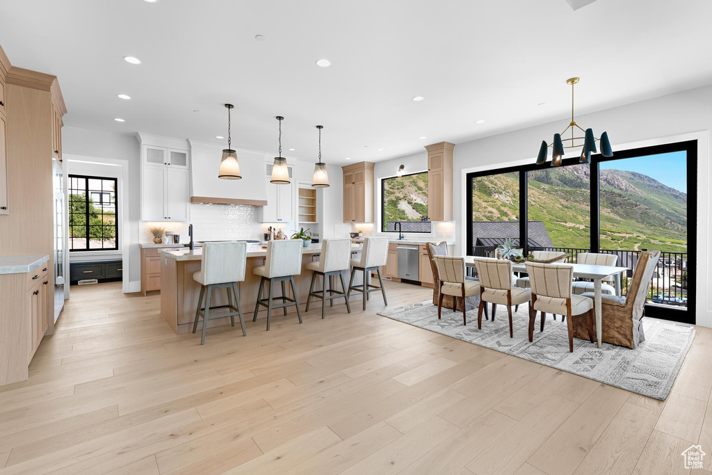 Dining area with light wood finished floors, recessed lighting, and a chandelier