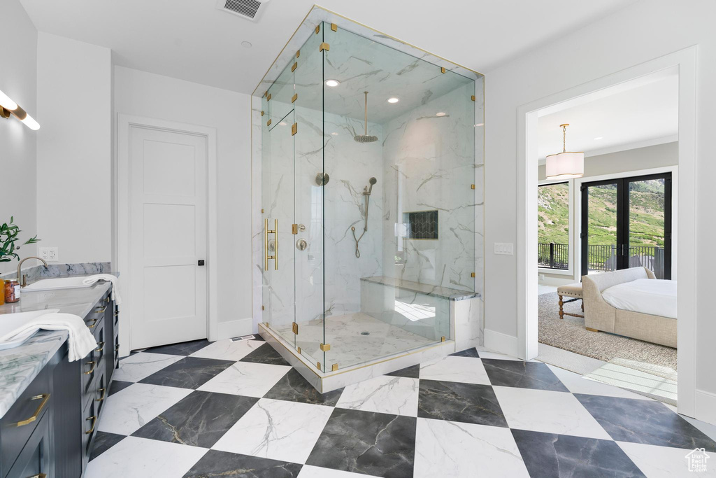 Ensuite bathroom with a marble finish shower, baseboards, double vanity, and recessed lighting
