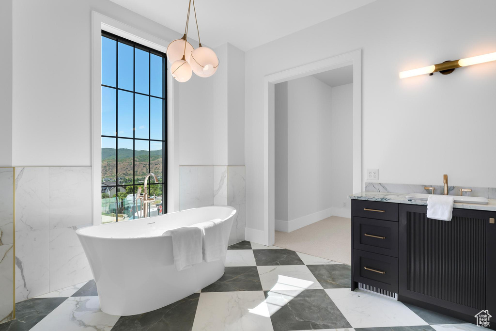 Bathroom featuring vanity, a freestanding bath, and marble tiled floors