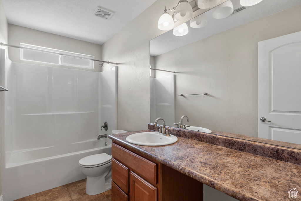 Full bath featuring  shower combination, toilet, vanity, and tile patterned floors