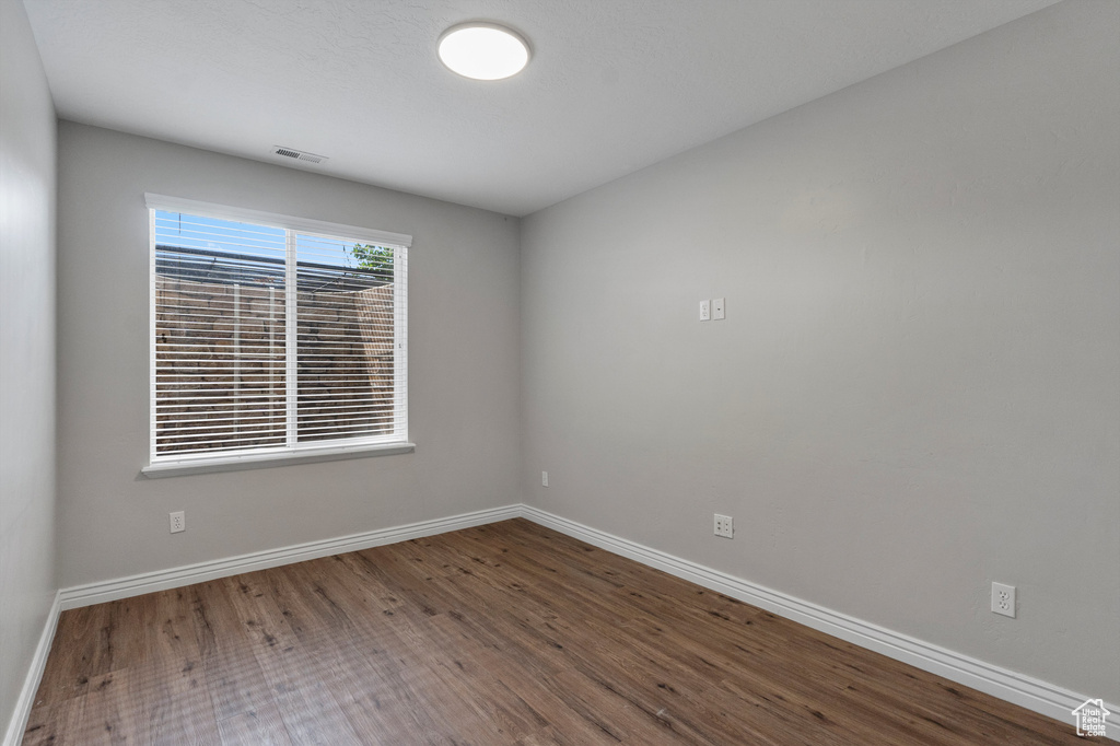 Unfurnished room featuring wood finished floors and baseboards