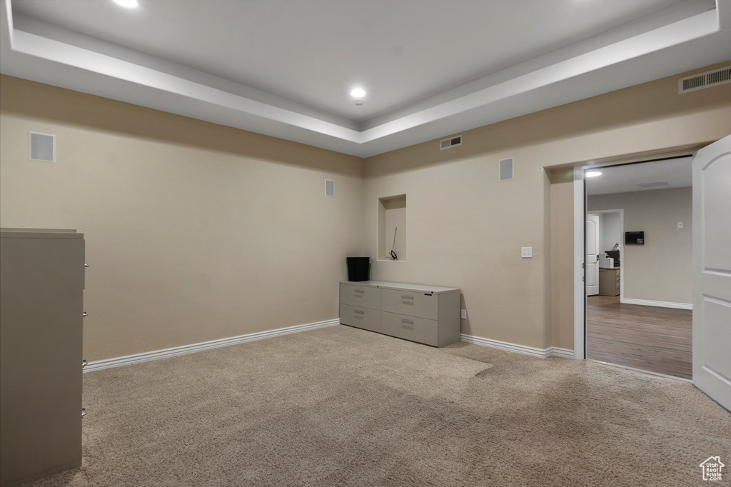 Unfurnished bedroom featuring carpet, a tray ceiling, baseboards, and recessed lighting