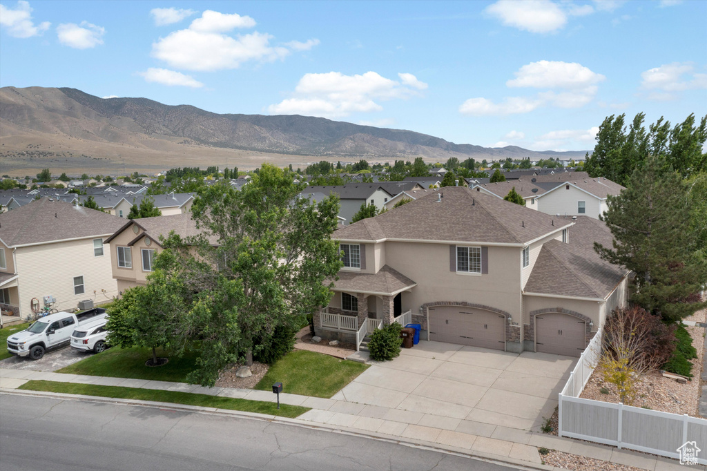View of front of property with stucco siding, a residential view, driveway, and a shingled roof