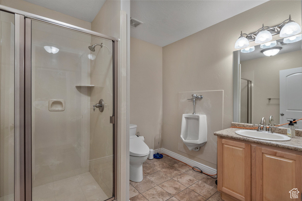 Full bath with toilet, vanity, a shower stall, and baseboards