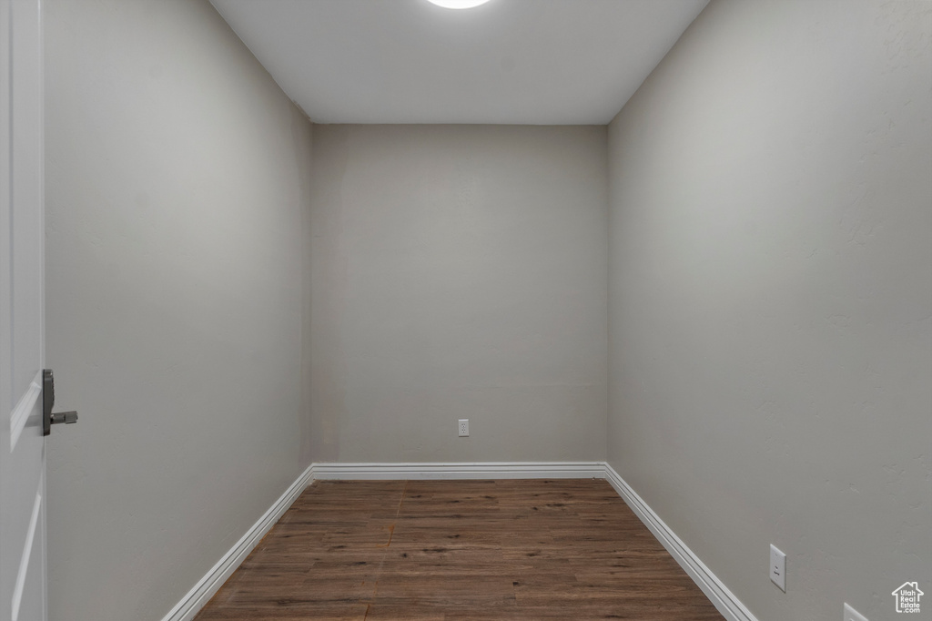 Spare room featuring dark wood-type flooring and baseboards