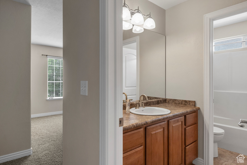 Bathroom featuring vanity, toilet, bathing tub / shower combination, and baseboards