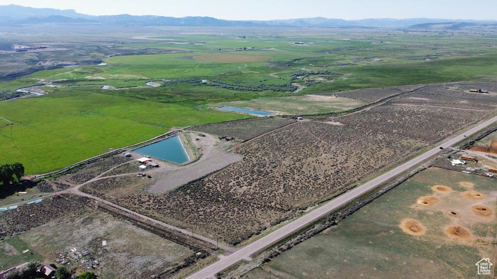 Aerial view of property and surrounding area with rural landscape and a mountain backdrop