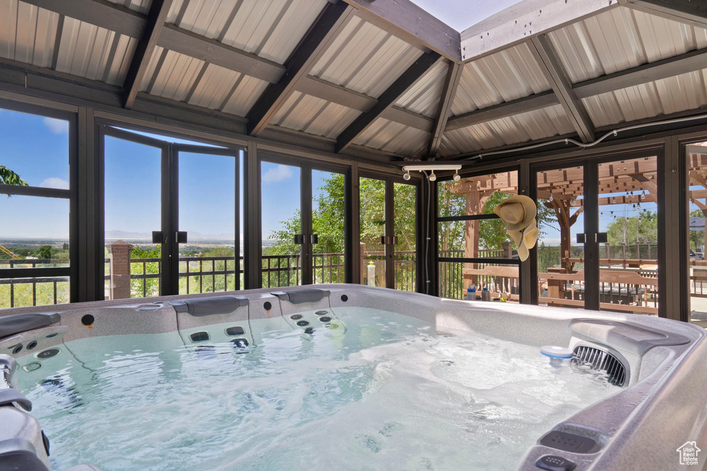 Sunroom / solarium featuring a hot tub, french doors, and plenty of natural light