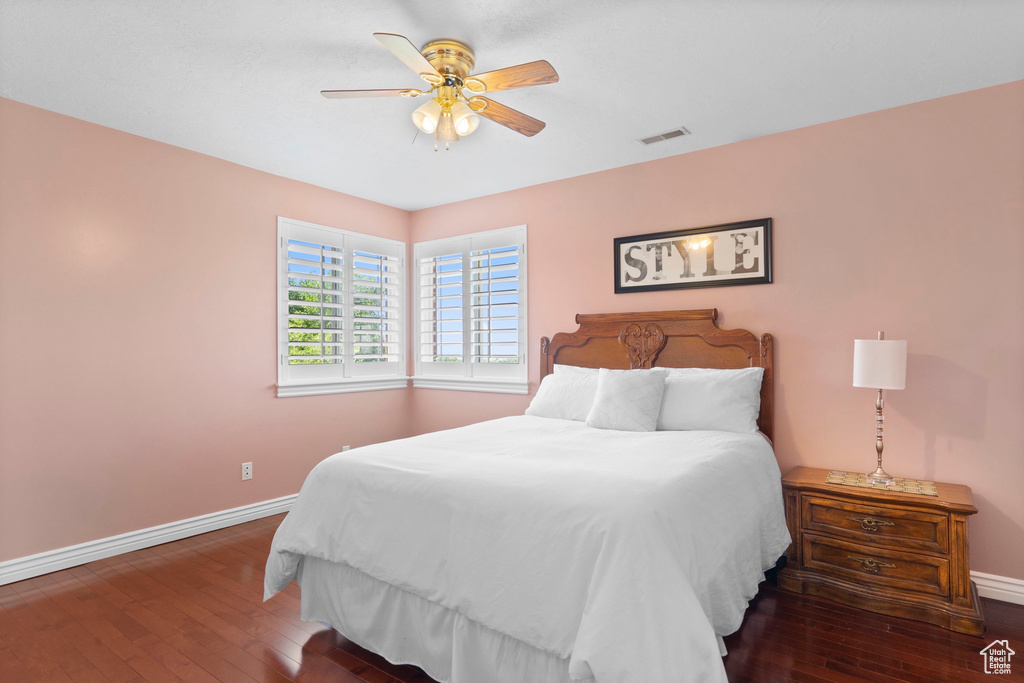 Bedroom featuring baseboards, hardwood / wood-style flooring, and a ceiling fan