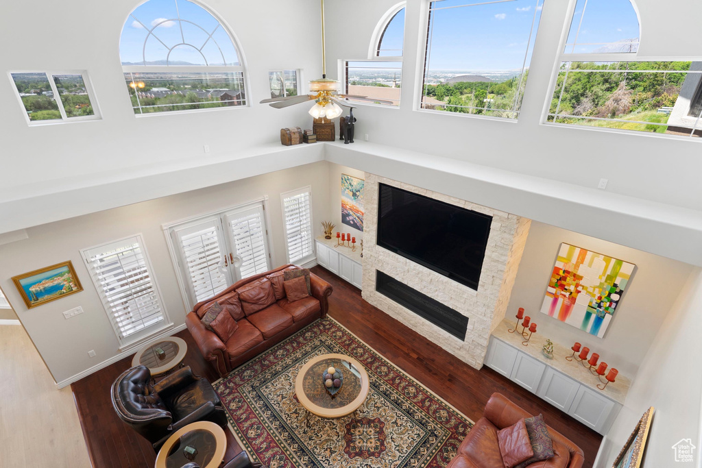 Living room with wood finished floors, a high ceiling, and ceiling fan