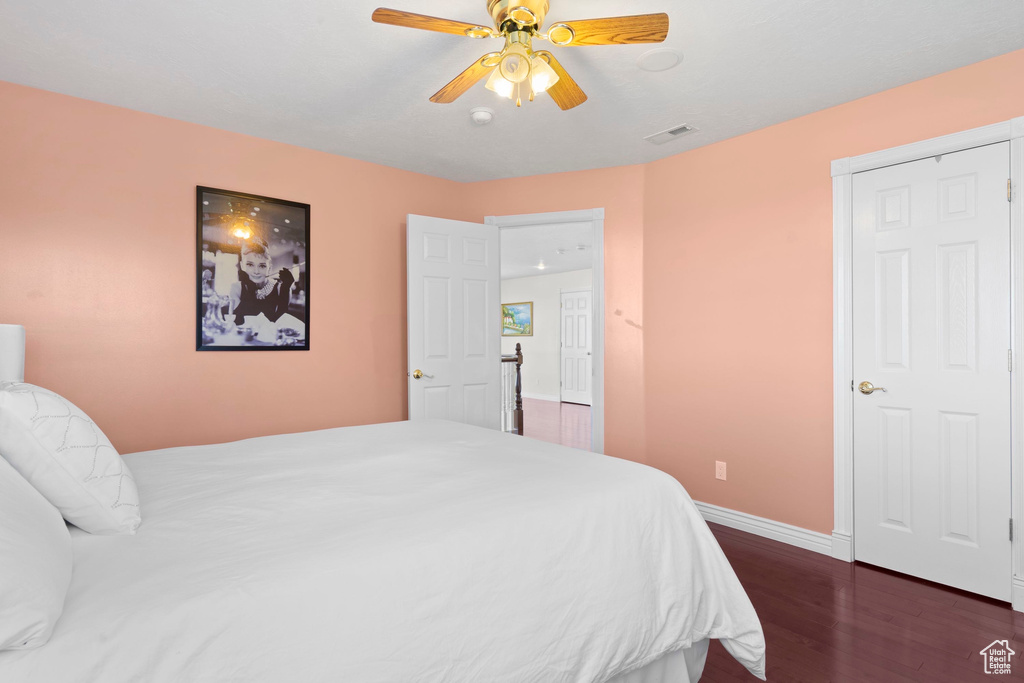 Bedroom featuring dark wood-style flooring, baseboards, and ceiling fan