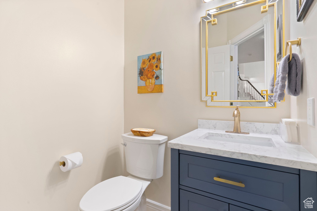 Bathroom featuring toilet, vanity, and baseboards