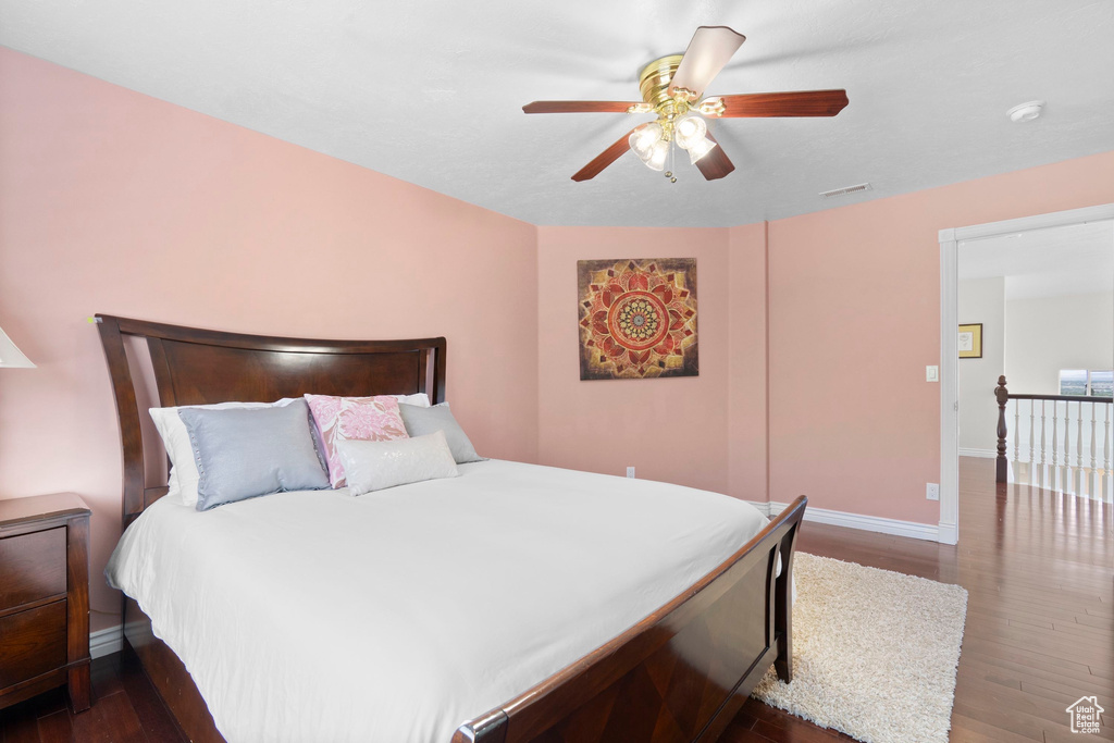 Bedroom with dark wood-style flooring, baseboards, and ceiling fan