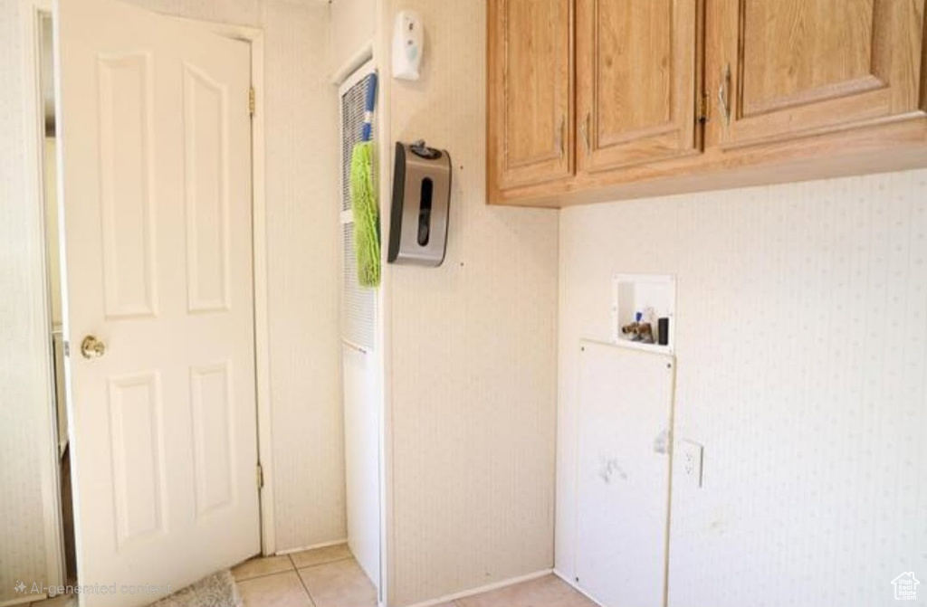 Washroom featuring cabinet space, hookup for a washing machine, and light tile patterned floors