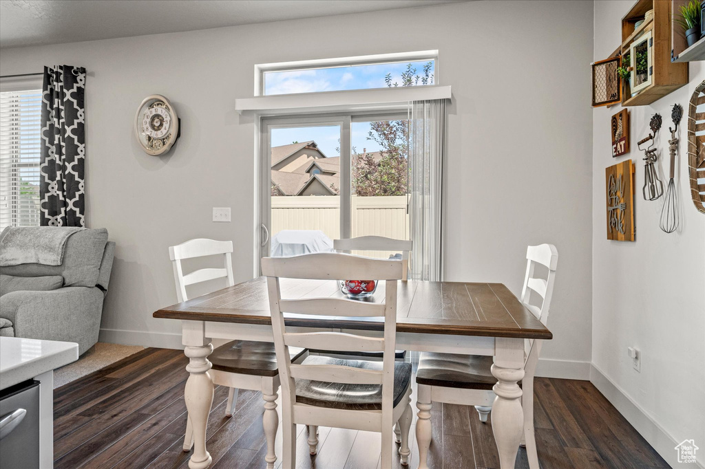 Dining room featuring dark wood-style floors and baseboards