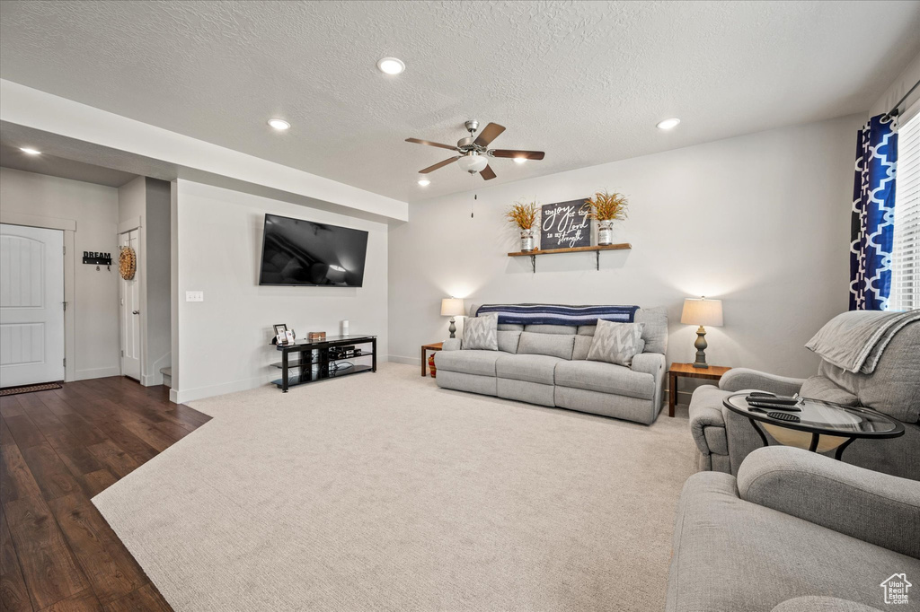 Living room featuring recessed lighting, a ceiling fan, a textured ceiling, baseboards, and wood finished floors