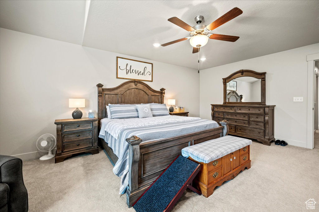 Bedroom featuring light carpet, baseboards, and a ceiling fan