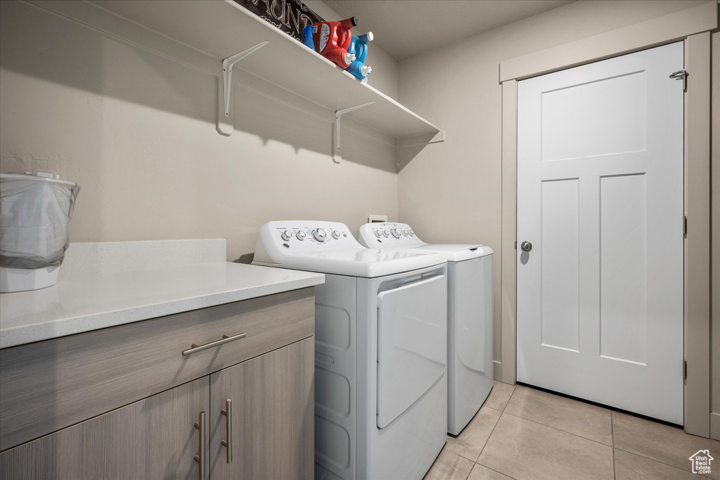 Laundry room featuring washing machine and clothes dryer and light tile patterned floors